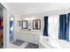 Bright bathroom featuring a double vanity with framed mirrors and a soaking tub with blue curtains at 4715 E 127Th Dr, Thornton, CO 80241