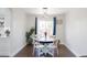 Cozy dining area with modern lighting, a round table, white chairs, and a large window overlooking the backyard at 4715 E 127Th Dr, Thornton, CO 80241