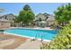 Community swimming pool with lounge area, tables, umbrellas, and landscaping at 8653 E Dry Creek Rd # 1121, Englewood, CO 80112