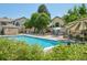 Enjoy this community pool with lounge chairs, tables, mature trees, and a view of the clubhouse at 8653 E Dry Creek Rd # 1121, Englewood, CO 80112
