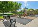 Community playground with slides, climbing structure, mulch, and bench seating at 8653 E Dry Creek Rd # 1121, Englewood, CO 80112