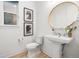 Half bathroom featuring a pedestal sink, round mirror, and stylish decor at 303 Rogers Ct, Castle Rock, CO 80104