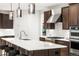 Modern kitchen with island featuring white countertops, stainless steel appliances, and dark wood cabinets at 303 Rogers Ct, Castle Rock, CO 80104