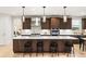 A stylish kitchen featuring a large island, modern appliances, pendant lighting, and dark wood cabinets at 303 Rogers Ct, Castle Rock, CO 80104