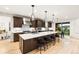 A stylish kitchen featuring a large island, modern appliances, pendant lighting, and dark wood cabinets at 303 Rogers Ct, Castle Rock, CO 80104