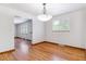 Open dining area with hardwood floors and a stylish light fixture at 6769 S Foresthill St, Littleton, CO 80120