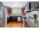 Well-lit kitchen with stainless steel appliances, granite countertops, and dark wood cabinets at 6769 S Foresthill St, Littleton, CO 80120