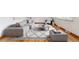Bright living room featuring a comfortable sectional sofa, wood floors, and a stylish patterned rug at 6769 S Foresthill St, Littleton, CO 80120
