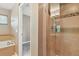 Bathroom featuring glass enclosed shower and soaking tub, with beige tiling and updated fixtures at 1484 Nemrick Pl, Castle Rock, CO 80109
