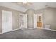 This bedroom features neutral tones, a ceiling fan, and doorways leading to a bathroom and a staircase at 1484 Nemrick Pl, Castle Rock, CO 80109