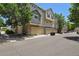 Row of townhomes with attached garages, stone accents and neutral paint under a sunny sky at 1484 Nemrick Pl, Castle Rock, CO 80109