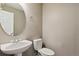 Cozy powder room featuring a modern sink, toilet, and decorative mirror at 1484 Nemrick Pl, Castle Rock, CO 80109