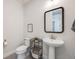 Stylish powder room features patterned tile floors, a pedestal sink, and modern fixtures at 11303 Tango Ln, Parker, CO 80134