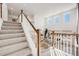 Bright home staircase with white railings and wood accents overlooking the living area with large windows at 11303 Tango Ln, Parker, CO 80134