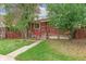 Inviting red-brick home featuring a cozy front porch with classic railing at 1457 S Franklin St, Denver, CO 80210