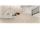 Carpeted basement area with a play tent, perfect for a cozy and inviting space at 7602 S Yakima Ct, Aurora, CO 80016