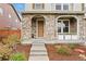 Charming home entrance with stone archway, brick accents, and landscaped garden at 7602 S Yakima Ct, Aurora, CO 80016