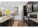 Modern kitchen boasts granite counters, stainless appliances, and dark cabinets at 7602 S Yakima Ct, Aurora, CO 80016