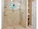 Beautifully tiled shower with seamless glass door features built-in shelving and a bright window at 4570 Irving St, Denver, CO 80211