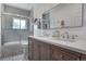Modern bathroom featuring double vanity, unique tile floor, and tub with shower at 4570 Irving St, Denver, CO 80211