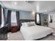 Comfortable bedroom featuring a large bed, soft blue walls, and dual windows with blackout curtains at 4570 Irving St, Denver, CO 80211