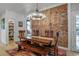 Inviting dining room featuring rustic wooden table, brick accent wall, and elegant chandelier at 4570 Irving St, Denver, CO 80211