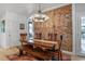 Inviting dining room featuring rustic wooden table, brick accent wall, and elegant chandelier at 4570 Irving St, Denver, CO 80211