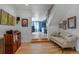 Inviting entryway with hardwood floors, staircase and view into the adjacent living room with blue accent wall at 4570 Irving St, Denver, CO 80211