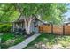 Charming home with gray stone facade, manicured front yard, mature trees, and a modern wood fence at 4570 Irving St, Denver, CO 80211