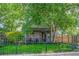 Charming home with well-maintained lawn, iron fence, mature trees, and stone facade at 4570 Irving St, Denver, CO 80211