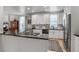 Open kitchen with stainless steel appliances and black countertops at 4570 Irving St, Denver, CO 80211