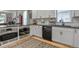 Bright modern kitchen features stainless steel appliances and white cabinets above a beautiful wood floor at 4570 Irving St, Denver, CO 80211