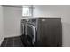 Modern laundry room boasts side-by-side washer and dryer units and sleek, dark tile flooring at 4570 Irving St, Denver, CO 80211