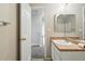Bright bathroom featuring a white vanity, sink and a medicine cabinet above the sink with an open door at 19721 E Vassar Ave, Aurora, CO 80013