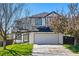 Charming two-story home featuring a white brick facade, well-maintained lawn, and an attached two-car garage at 19721 E Vassar Ave, Aurora, CO 80013
