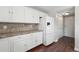 Bright kitchen features white cabinets, tile backsplash and stainless steel refrigerator at 19721 E Vassar Ave, Aurora, CO 80013