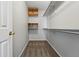 Walk-in closet featuring neutral walls, carpet, wire shelves, and wooden cabinets at 19721 E Vassar Ave, Aurora, CO 80013