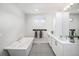Modern bathroom with a soaking tub, dual vanities, and sleek, contemporary finishes at 6 Wilder Ln, Littleton, CO 80123
