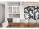 Elegant dining area with a built-in bar, wine fridge, and modern lighting and art at 6 Wilder Ln, Littleton, CO 80123