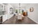Dining room with long wood table, modern chandelier, and an adjacent bar area with wine refrigerator at 6 Wilder Ln, Littleton, CO 80123