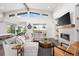 Open-concept living room with high ceilings, fireplace, modern furniture, and adjacent kitchen and dining area at 6 Wilder Ln, Columbine Valley, CO 80123