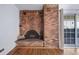 Living room with a brick fireplace and screen, plus hardwood floors, and access to the balcony at 1350 Josephine St # 508, Denver, CO 80206