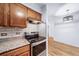 Kitchen featuring stainless steel appliances, granite countertops, tile backsplash, and oak cabinets at 1350 Josephine St # 508, Denver, CO 80206