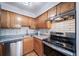 Kitchen featuring a stainless steel range, granite countertops, tile backsplash, and oak cabinets at 1350 Josephine St # 508, Denver, CO 80206