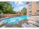 Community pool surrounded by brick fencing with ample seating and lounging at 1350 Josephine St # 508, Denver, CO 80206