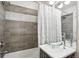 Modern bathroom with glass sink, gray tile, and shower/tub combo at 1615 Julian St # 102, Denver, CO 80204