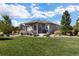 Covered patio with seating area, adjacent to a well-manicured lawn at 25146 E 1St Ave, Aurora, CO 80018