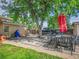 A cozy backyard featuring an outdoor dining set, mature tree, and a storage shed at 7751 Niagara St, Commerce City, CO 80022