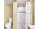 Bathroom with tile flooring, toilet, and a tiled shower with a patterned shower curtain at 7751 Niagara St, Commerce City, CO 80022