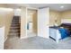 Cozy carpeted bedroom with a doorway to laundry area and stairs at 7751 Niagara St, Commerce City, CO 80022